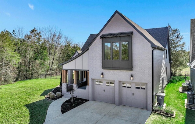 view of side of home featuring brick siding, a yard, concrete driveway, fence, and a garage