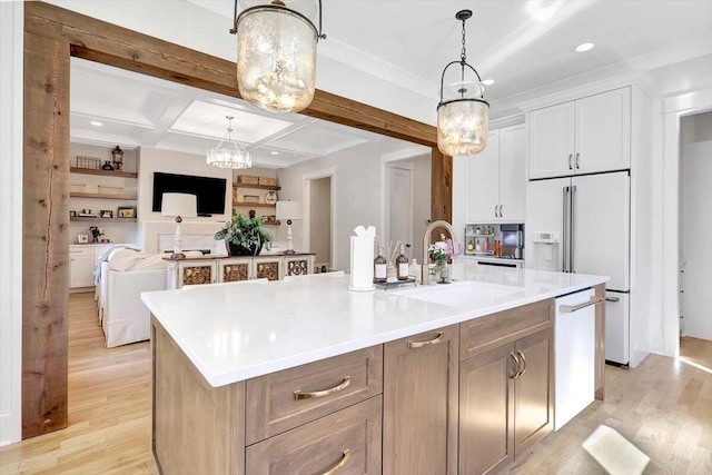 kitchen featuring open floor plan, white dishwasher, a large island with sink, white cabinetry, and a sink