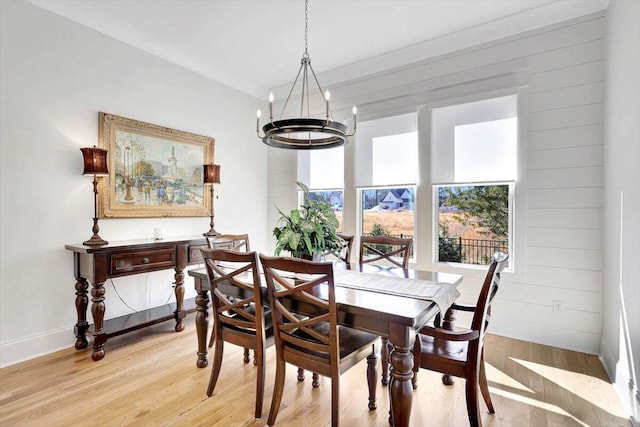 dining space featuring wood walls and light wood-style flooring