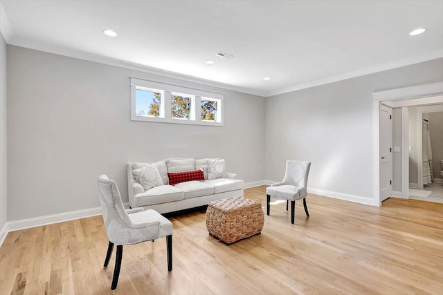 living area with recessed lighting, light wood-style flooring, baseboards, and ornamental molding