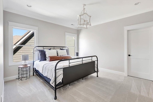 bedroom with light carpet, multiple windows, and baseboards