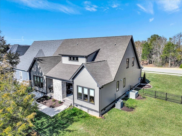 view of front of house with crawl space, roof with shingles, a front yard, and fence