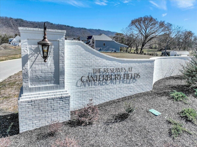 community / neighborhood sign with a mountain view