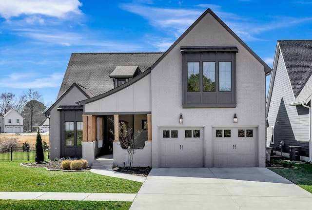 view of front facade featuring driveway, a garage, fence, a front yard, and brick siding