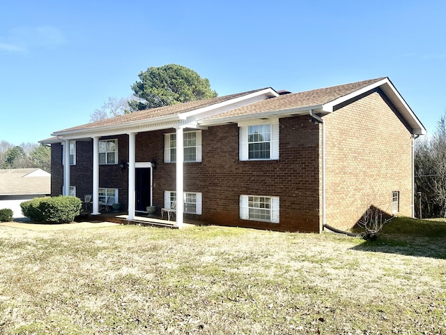 split foyer home featuring brick siding and a front yard