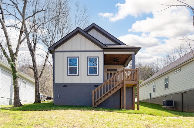 back of property featuring stairway, a ceiling fan, central AC, a lawn, and board and batten siding