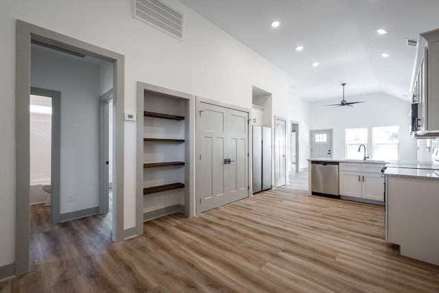 kitchen with a sink, visible vents, stainless steel dishwasher, and light wood finished floors