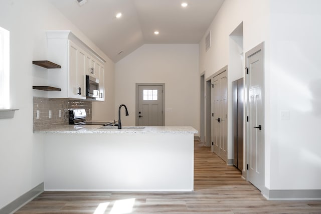 kitchen featuring visible vents, appliances with stainless steel finishes, a peninsula, white cabinetry, and a sink