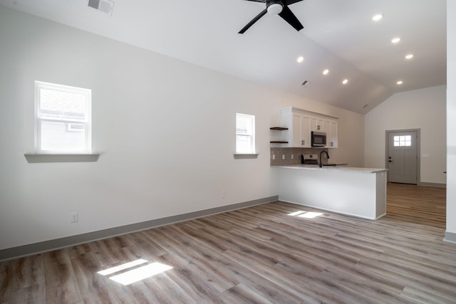 interior space featuring visible vents, light countertops, stainless steel appliances, white cabinetry, and open shelves