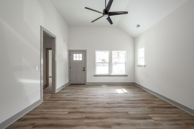 foyer entrance featuring a ceiling fan, visible vents, baseboards, high vaulted ceiling, and light wood-style floors