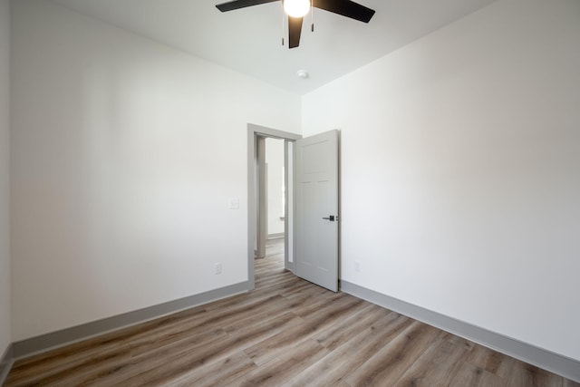 empty room featuring baseboards, light wood-type flooring, and ceiling fan