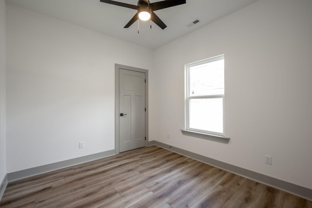 spare room with visible vents, baseboards, light wood-style floors, and a ceiling fan