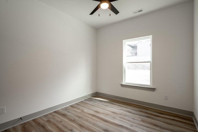 unfurnished room with a ceiling fan, light wood-style flooring, baseboards, and visible vents