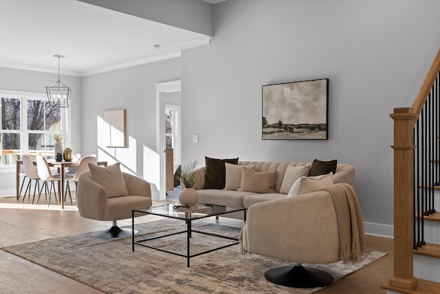 living room with a chandelier, baseboards, wood finished floors, and crown molding