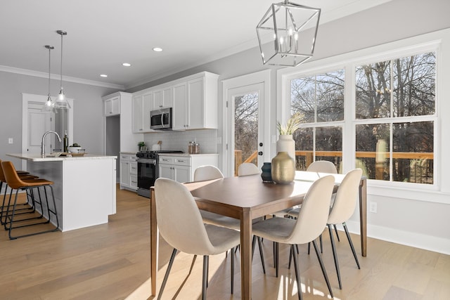 dining room with light wood-style floors, recessed lighting, crown molding, and baseboards
