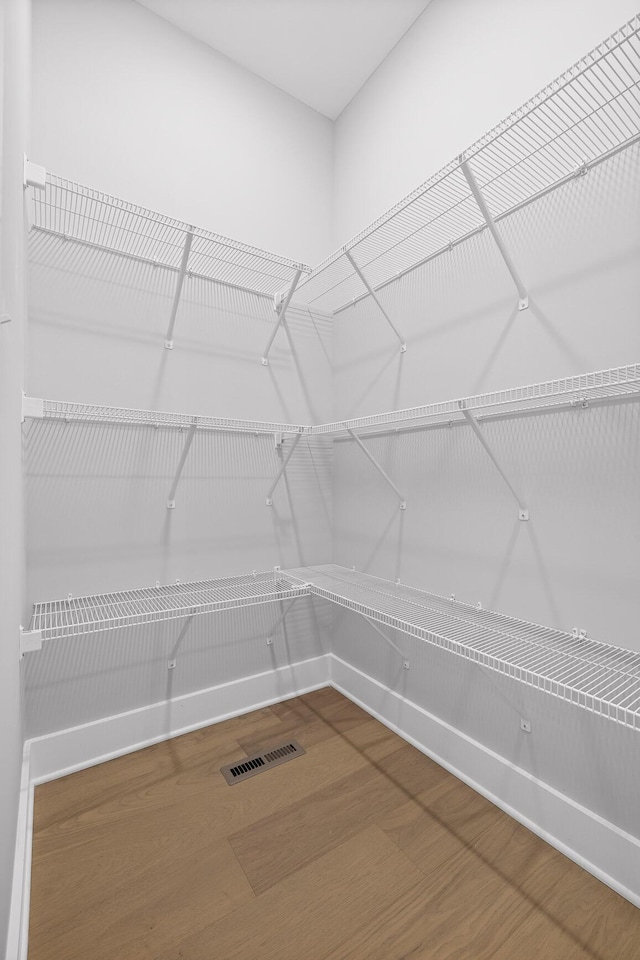walk in closet with visible vents and wood finished floors