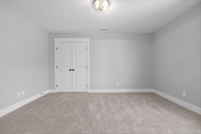 carpeted empty room featuring baseboards and visible vents