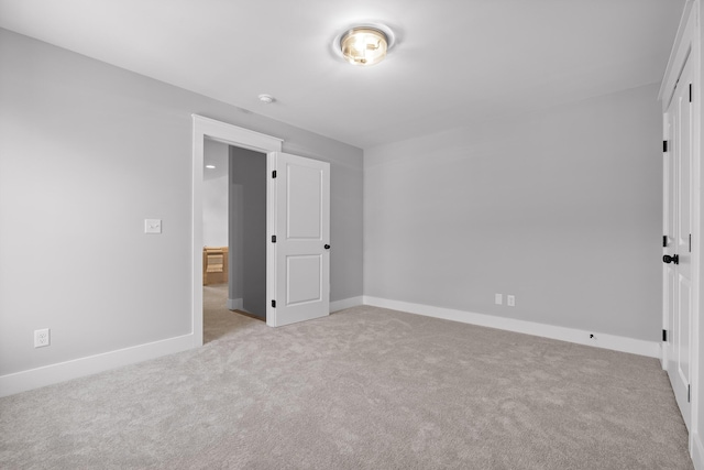 unfurnished bedroom featuring light carpet and baseboards