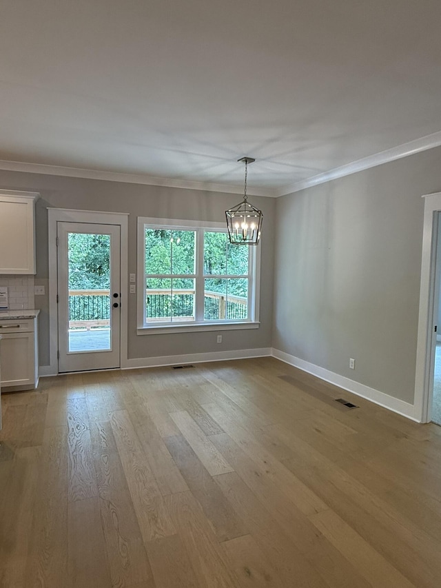 7189 Paxton Cir Unit 32, Hixson, TN 37343 - unfurnished dining area featuring a chandelier, light wood-style flooring, and ornamental molding