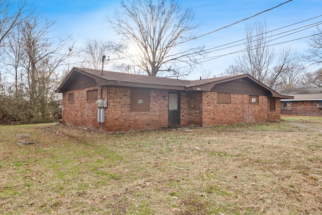 exterior space featuring brick siding and a front lawn