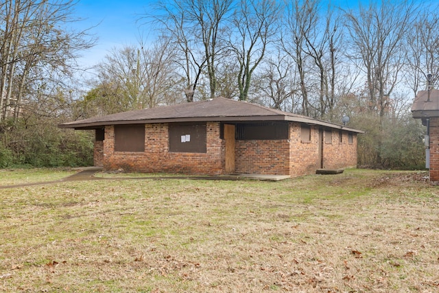 view of home's exterior with a lawn and brick siding