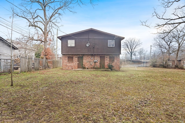 back of property featuring a yard, a fenced backyard, and brick siding