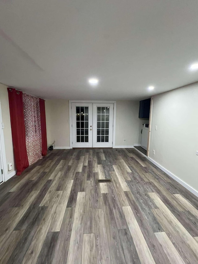 unfurnished living room with baseboards, wood finished floors, and french doors