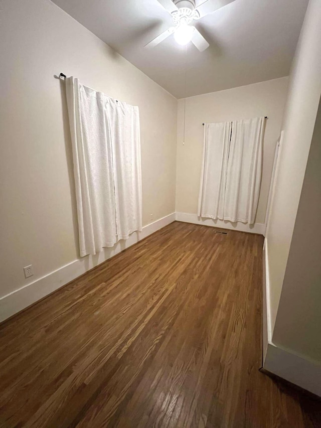 unfurnished room featuring ceiling fan, baseboards, and wood finished floors