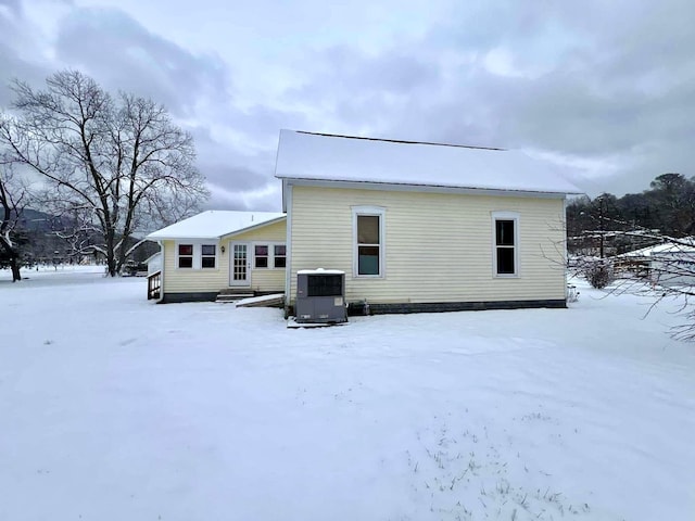 snow covered rear of property with cooling unit