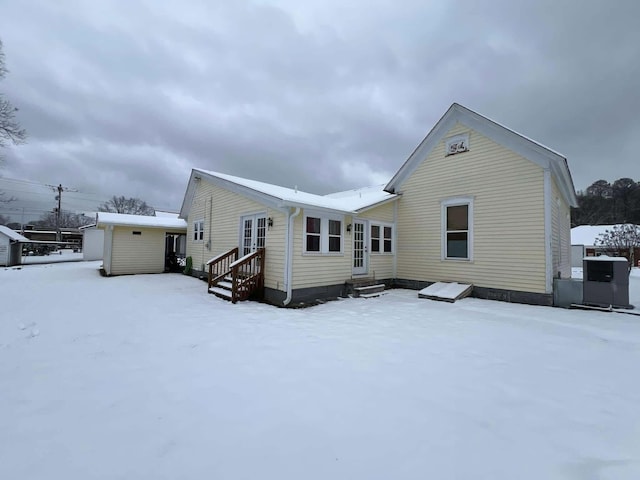 snow covered back of property with entry steps