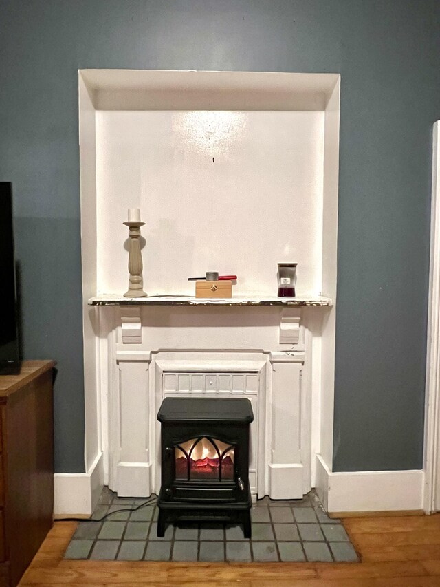 room details with a wood stove and wood finished floors