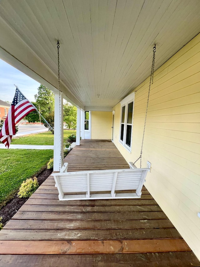deck featuring a lawn and covered porch