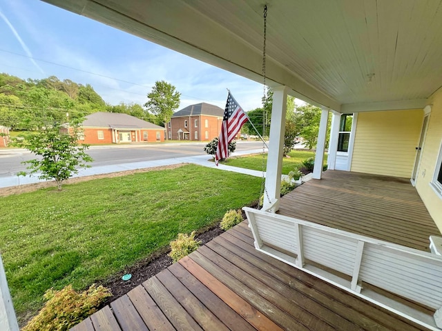 wooden deck featuring a yard and a porch