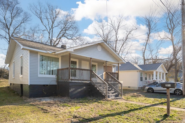 bungalow featuring covered porch, a front lawn, and crawl space