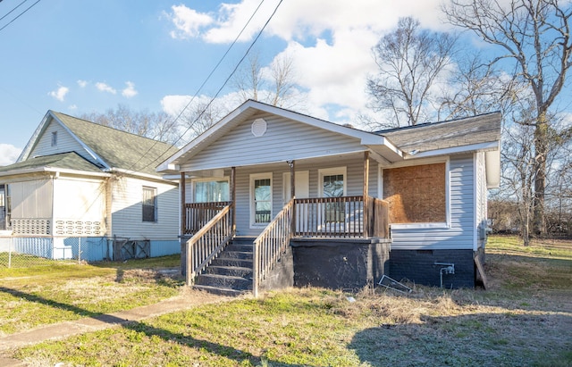 view of front of property with covered porch, a front lawn, crawl space, and stairway