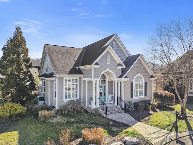 view of front of property with a shingled roof and a front yard