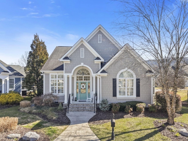 view of front of house with a front yard and roof with shingles