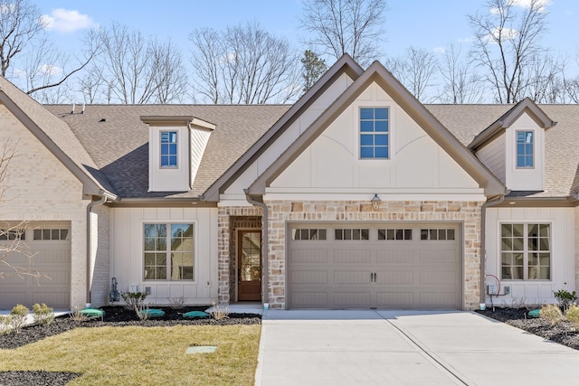 view of front of property with board and batten siding, stone siding, roof with shingles, and an attached garage