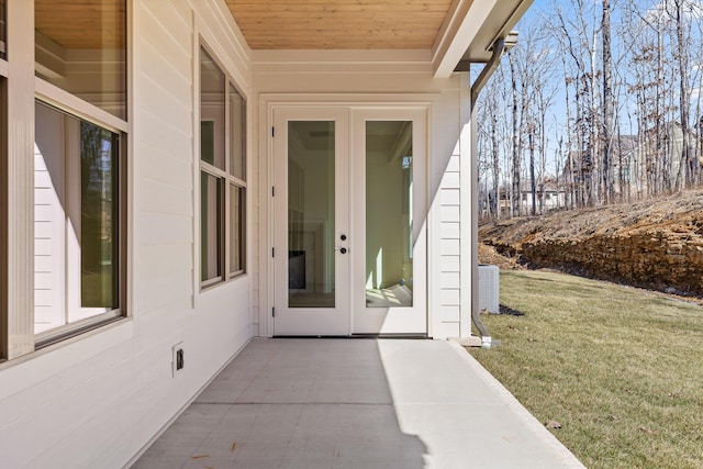 entrance to property with central AC, a yard, and a patio