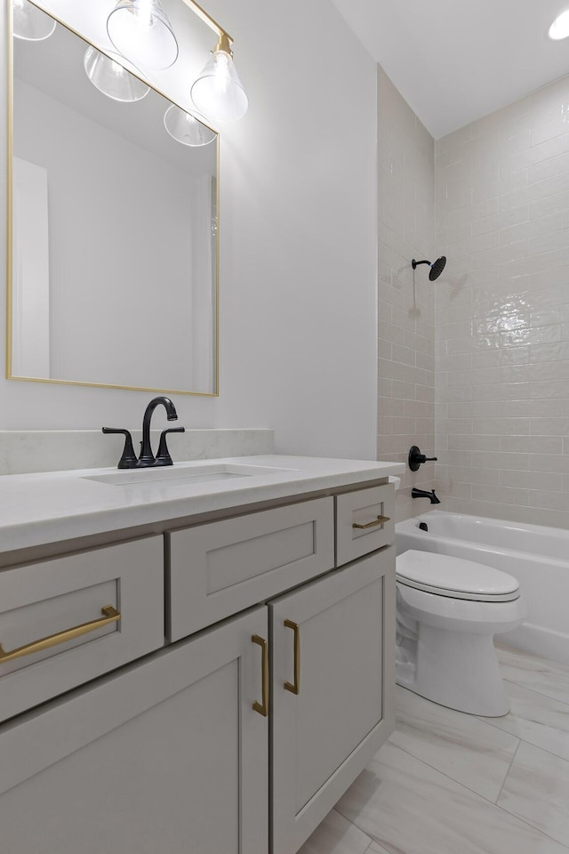 full bath with washtub / shower combination, marble finish floor, vanity, and toilet