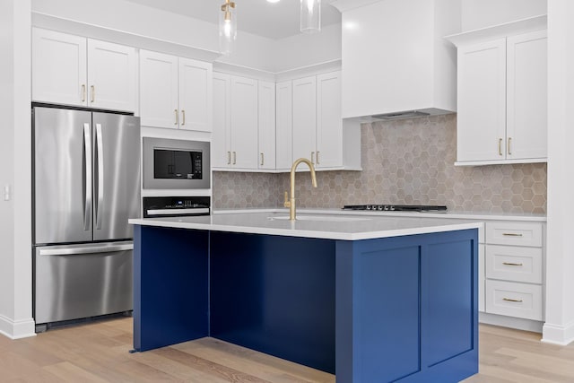 kitchen with stainless steel appliances, light countertops, and white cabinetry