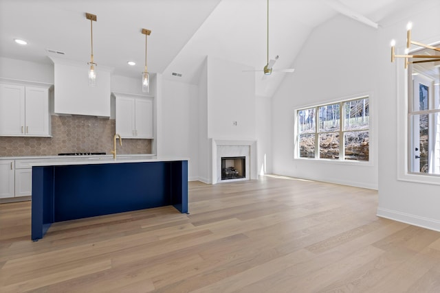 kitchen featuring light countertops, open floor plan, white cabinetry, and a kitchen breakfast bar