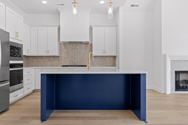 kitchen with light countertops, hanging light fixtures, visible vents, appliances with stainless steel finishes, and white cabinetry