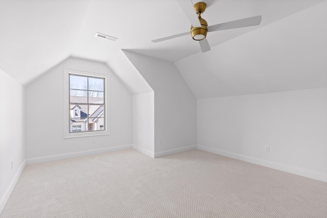 additional living space with baseboards, visible vents, a ceiling fan, light colored carpet, and lofted ceiling