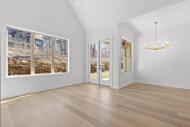 empty room with light wood-style flooring, baseboards, and an inviting chandelier