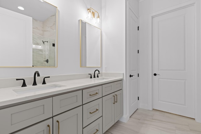 full bathroom featuring double vanity, a stall shower, and a sink