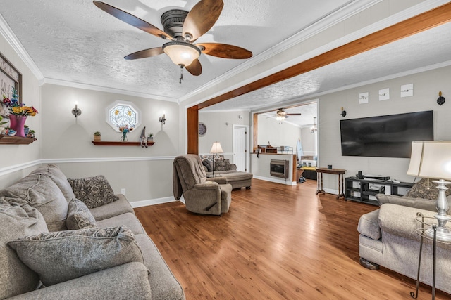 living area featuring crown molding, a textured ceiling, and wood finished floors