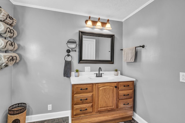 bathroom featuring baseboards, ornamental molding, a textured ceiling, and vanity