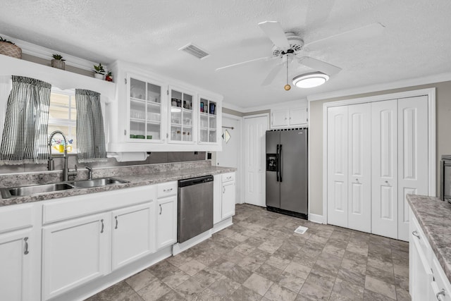 kitchen featuring white cabinets, glass insert cabinets, stainless steel appliances, and a sink