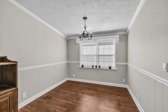 unfurnished dining area featuring visible vents, wainscoting, dark wood-type flooring, a textured ceiling, and a notable chandelier